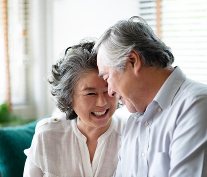 Two older adults smiling at each other after visiting Delta Dental dentist in Fort Lee 