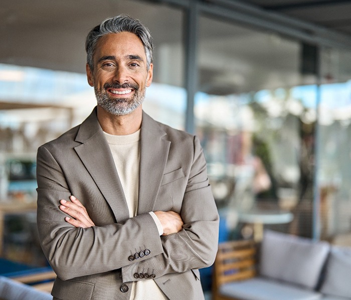 Man at work smiling confidently with his dentures in Denton
