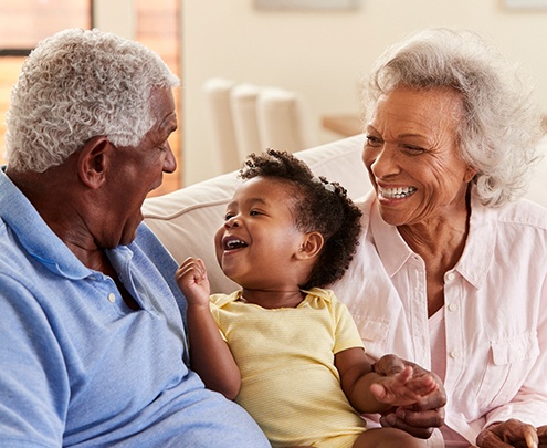 Grandparents smiling and having fun with their grandchild