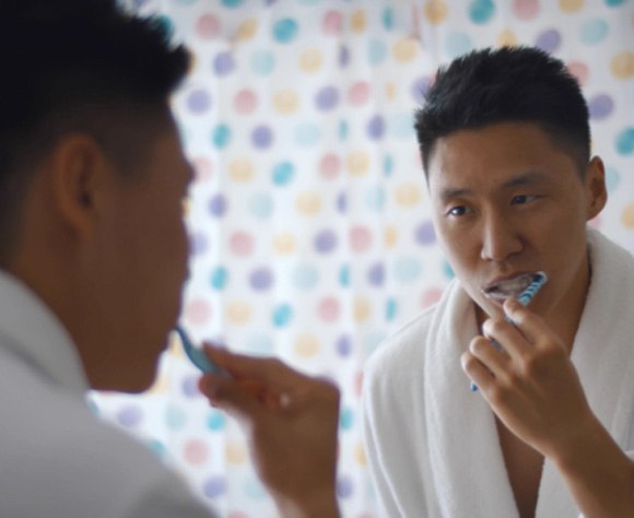 Person brushing teeth at home to prevent dental emergencies in Fort Lee 