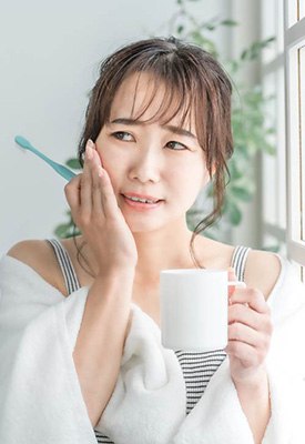 Patient in Englewood Cliffs holding cheek at dentist